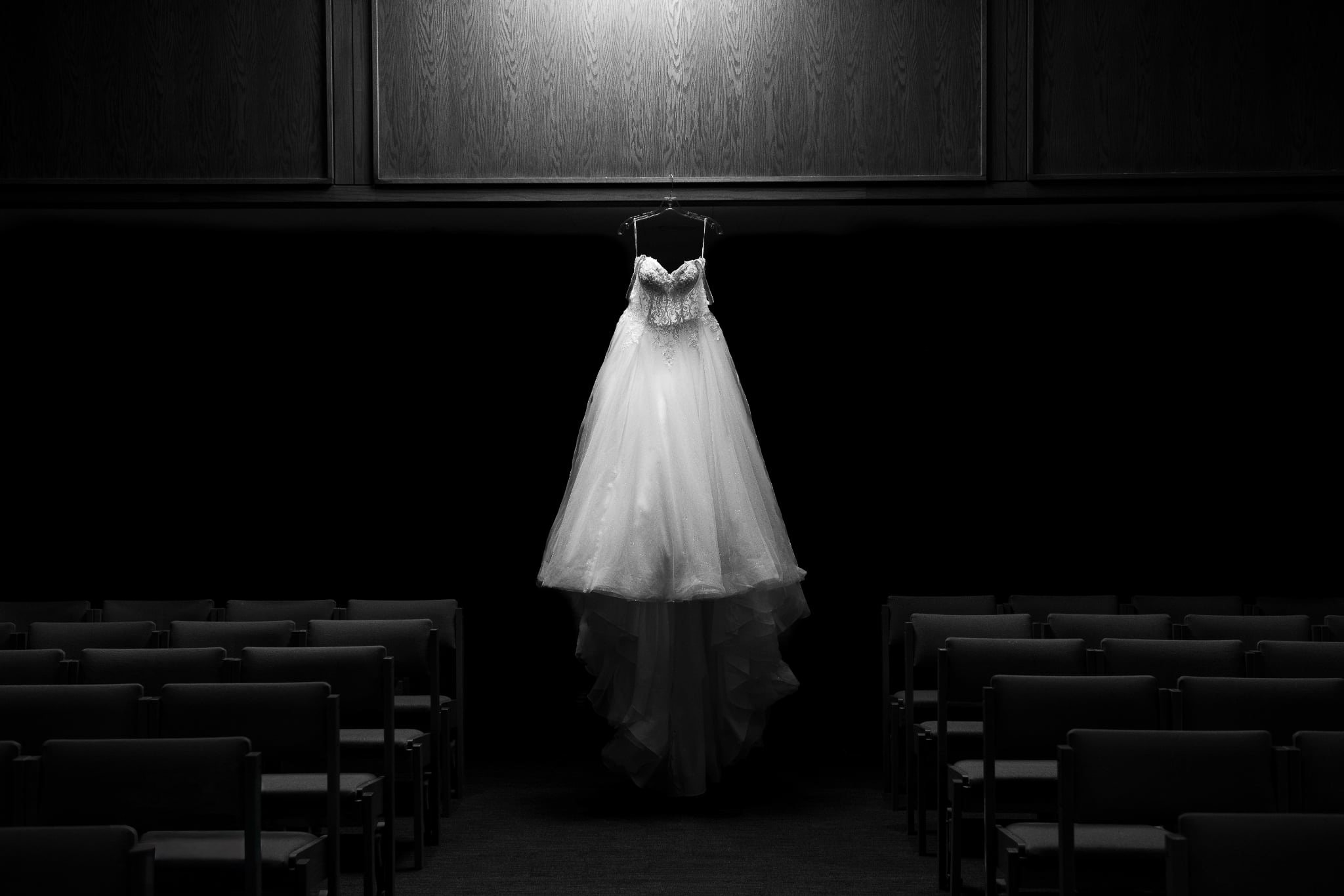 Jocilyn's wedding dress hanging above the empty ceremony aisle