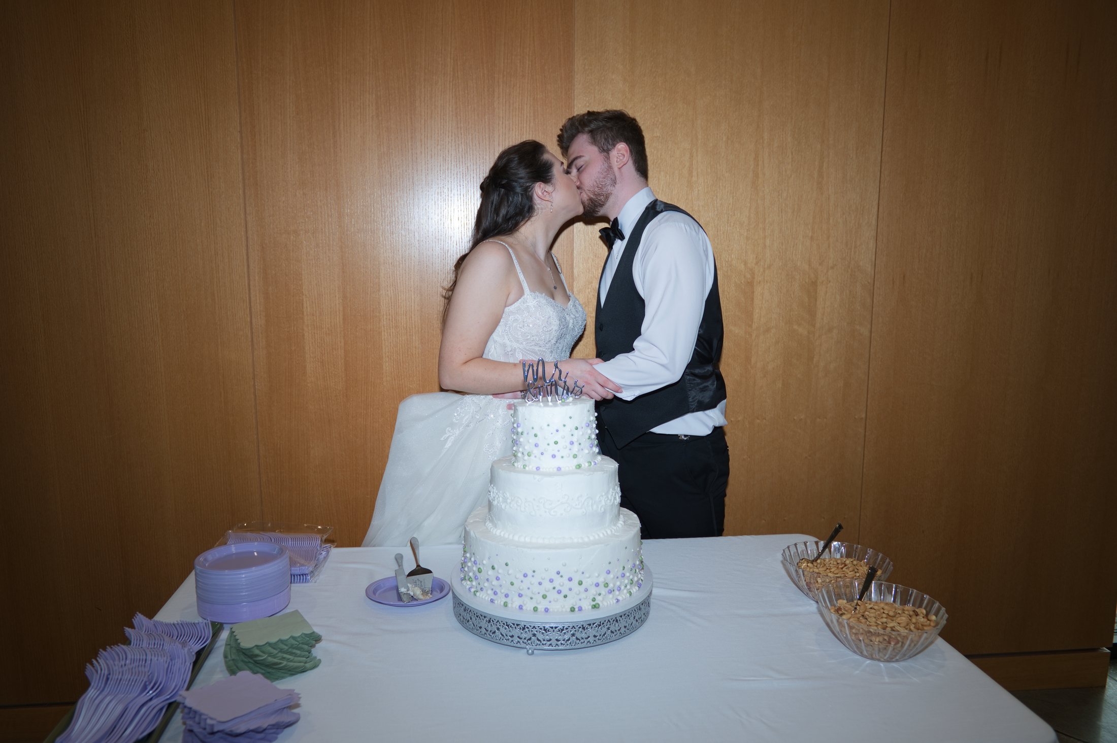 Brennan and Jocilyn kissing behind their wedding cake